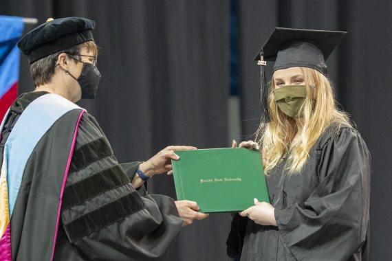 President Faith C. Hensrud confers a diploma