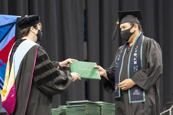 President Faith C. Hensrud confers a diploma