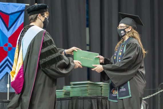 President Faith C. Hensrud confers a diploma
