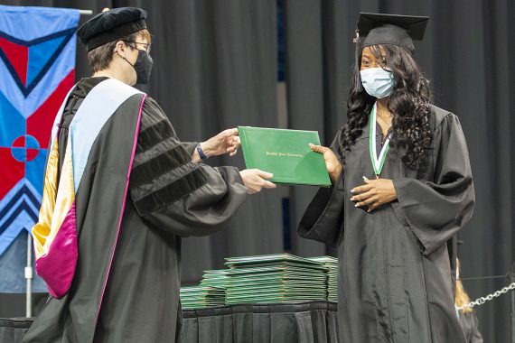 President Faith C. Hensrud confers a diploma