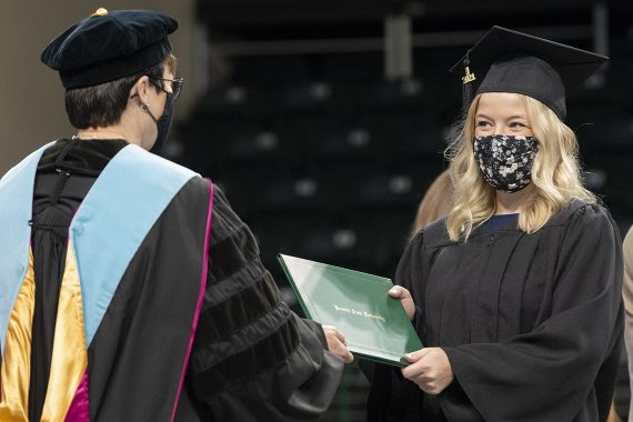 President Faith C. Hensrud confers a diploma