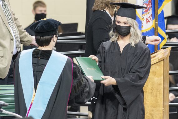 President Faith C. Hensrud confers a diploma