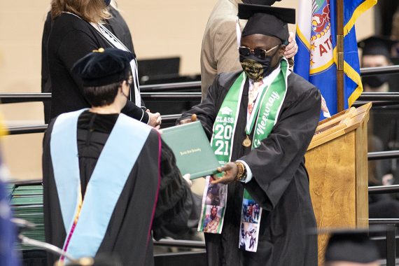 President Faith C. Hensrud confers a diploma