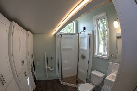 Bemidji State University tiny house Three-quarter bathroom with 32&rdquo; Stylemate Neo Angle shower enclosure, ProFlo flush toilet prewired for an optional composting toilet and full-height storage cabinets.
