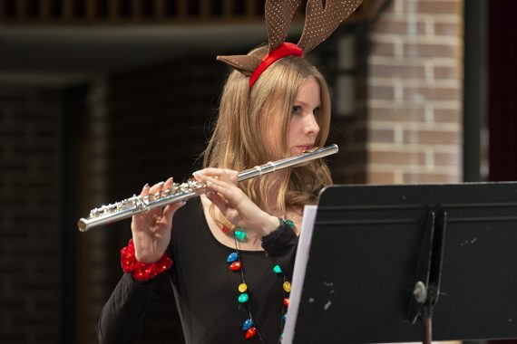 Sarah Urschel performing wearing a glowing necklace and reindeer antlers at the Bemidji State Jingle Pops concert