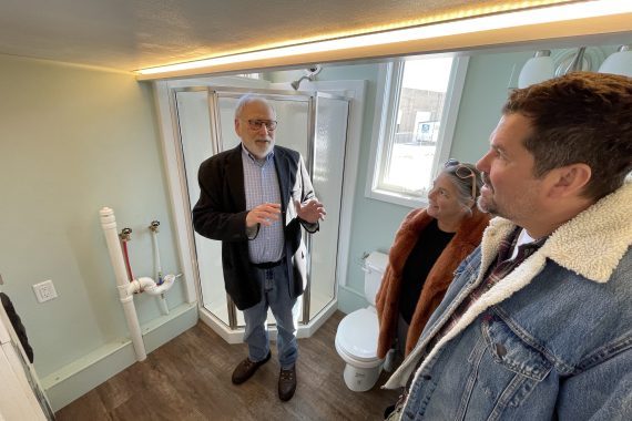 Tim Brockman, professor of technology, art and design, giving Ginny and Chris Kelly a tour of the tiny house