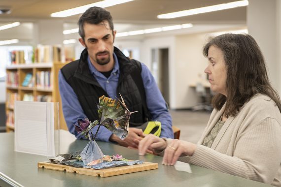 BSU Staff viewing a "Books Unbound" art piece