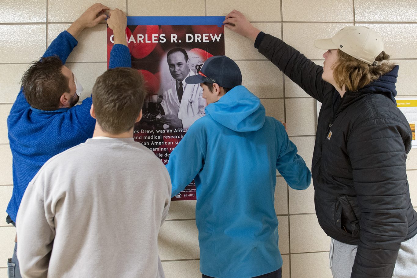 Bemidji State University's Mitch Blessing, Jack Ryan, Sam Pinkerton, and Breck Henderson installing the posters in Sattgast Hall