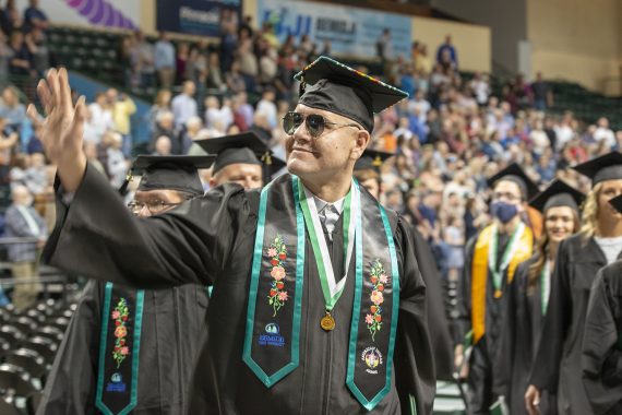 A Bemidji State University graduate waving to the audience