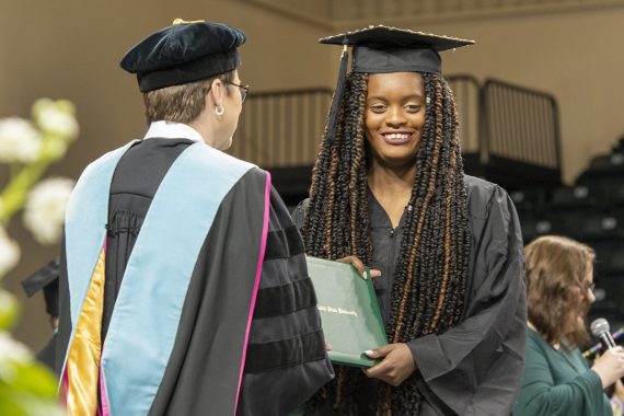 A Bemidji State University graduate receiving a diploma