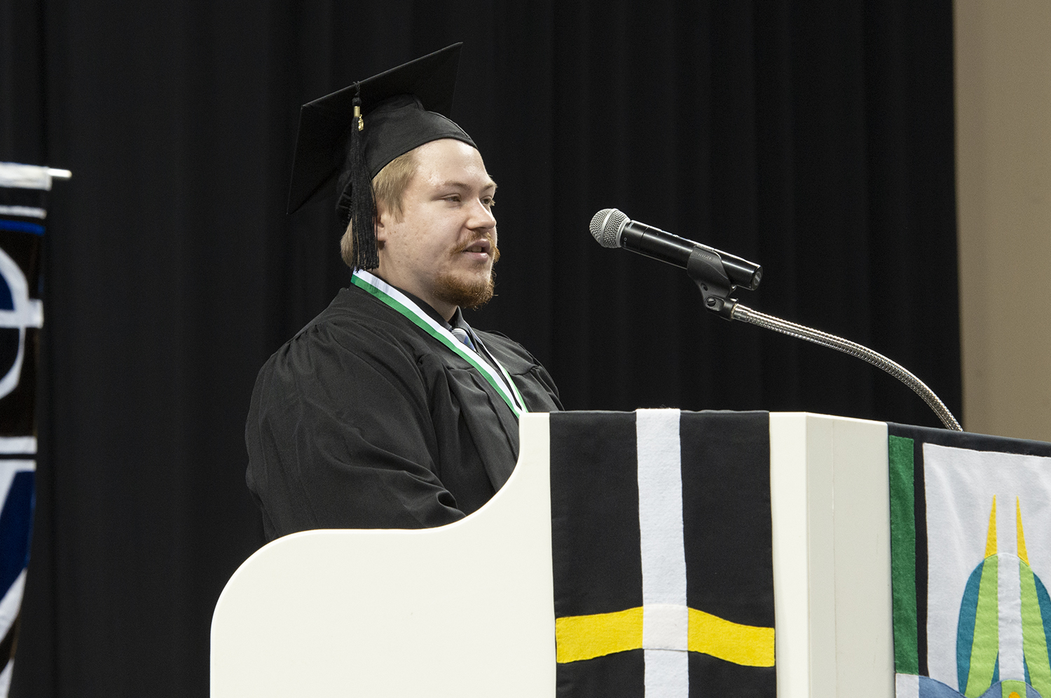 Tristan Heller on stage presenting a 2022 commencement address 