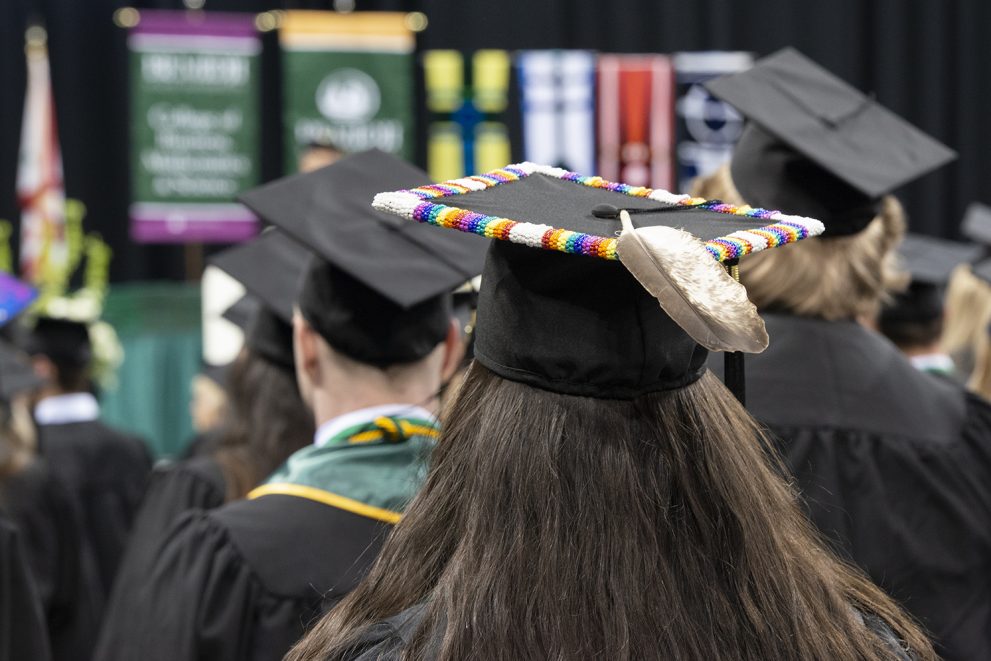 A beaded Bemidji State University Class of 2022 grad cap with an Eagle feather