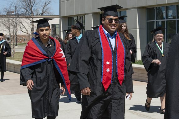 BSU Graduates walking in the Commencement processional outside Bemidji's Sanford Center