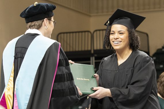 A Bemidji State University graduate receiving a diploma