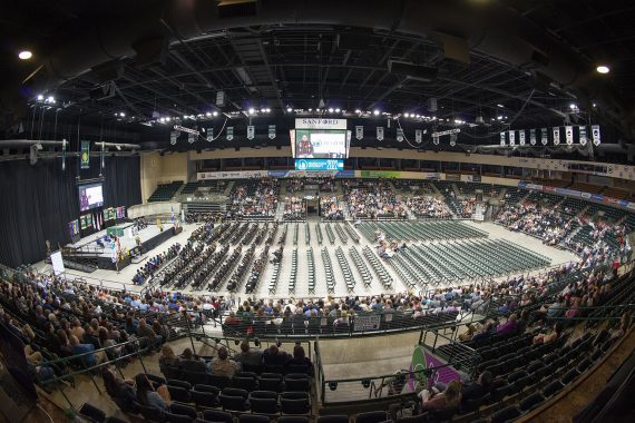 Graduates sitting and listening to a commencement address