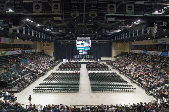 Graduates sitting and listening to a commencement address