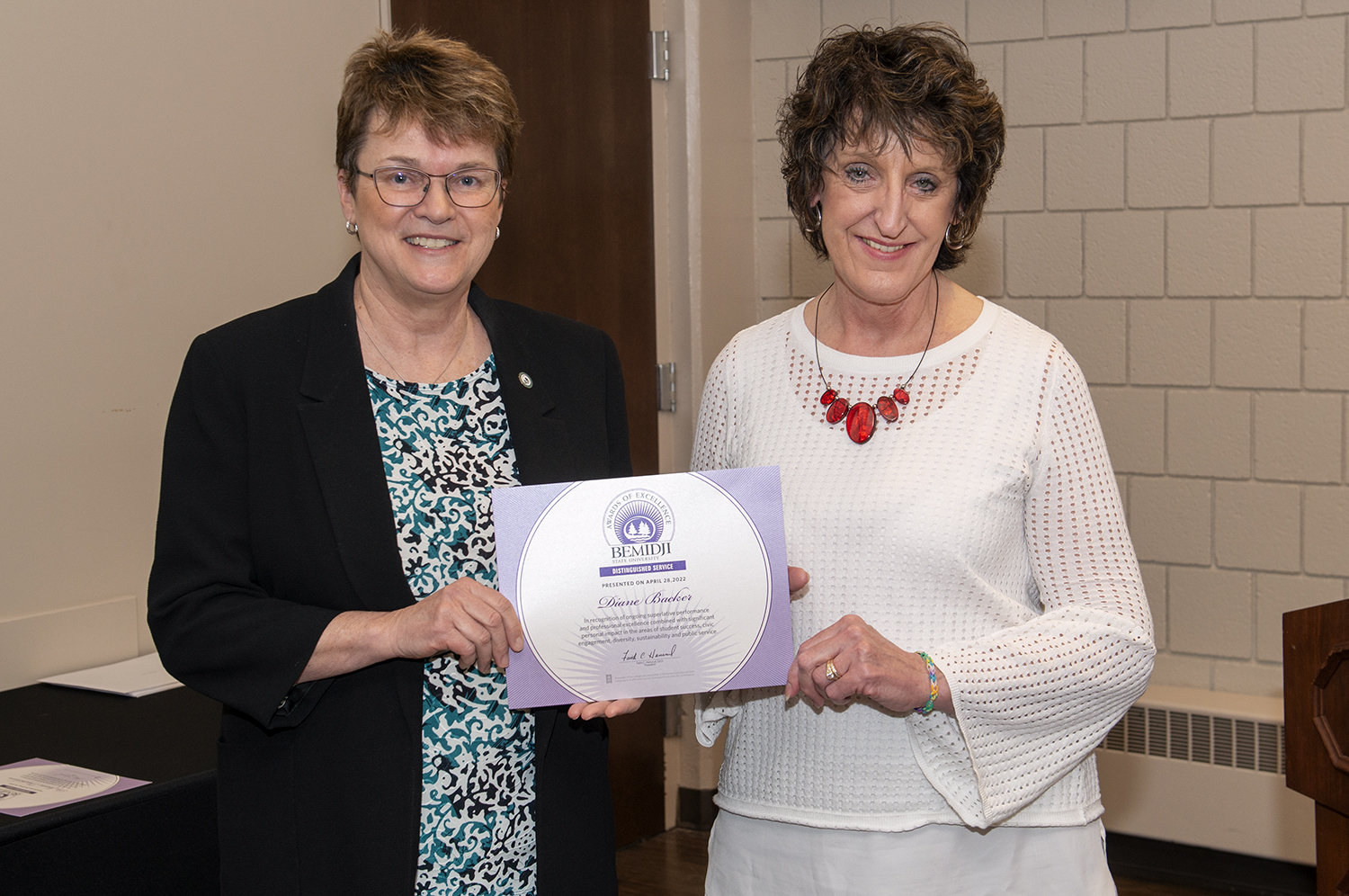 President Faith Hensrud presents Diane Backer, executive assistant to the president, the Distinguished Service award