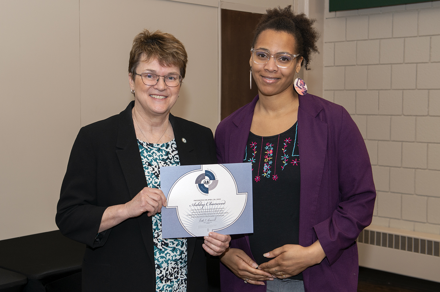 President Faith Hensrud presents Ashley Charwood, assistant professor of social work, the Shared Fundamental Values in Community Engagement award.