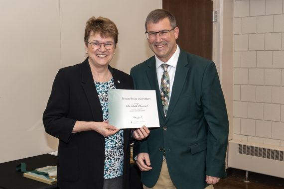 Provost Allen Bedford presenting President Faith C. Hensrud a retirement certificate.