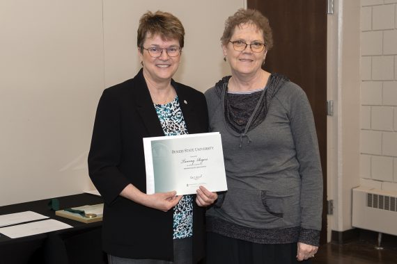 President Faith Hensrud presenting Tammy Rogers, accounting technician, a retirement certificate.