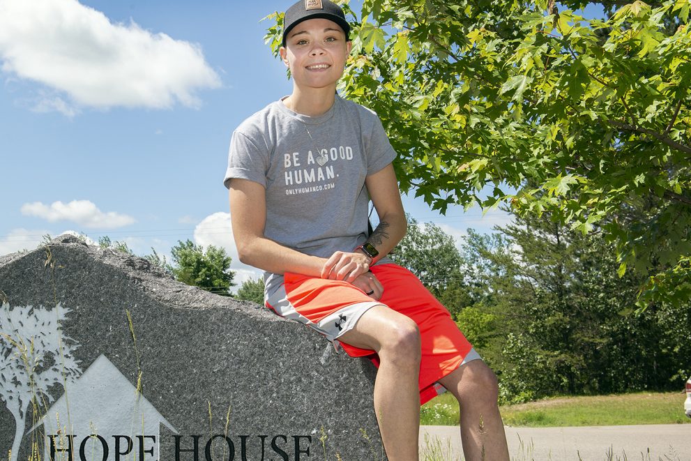 Donna Velishek sitting on a rock outside the Hope House in Grand Rapids, Minnesota.