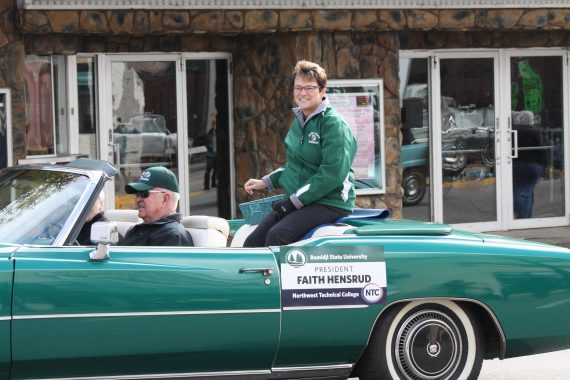 BSU President Hensrud and her husband, Neil, riding in a green Cadillac convertible with the top down during a BSU Homecoming parade