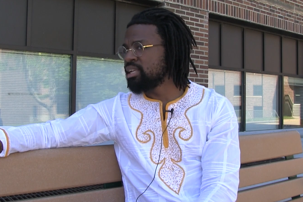 Steven Parker sitting on a bench outside of campus