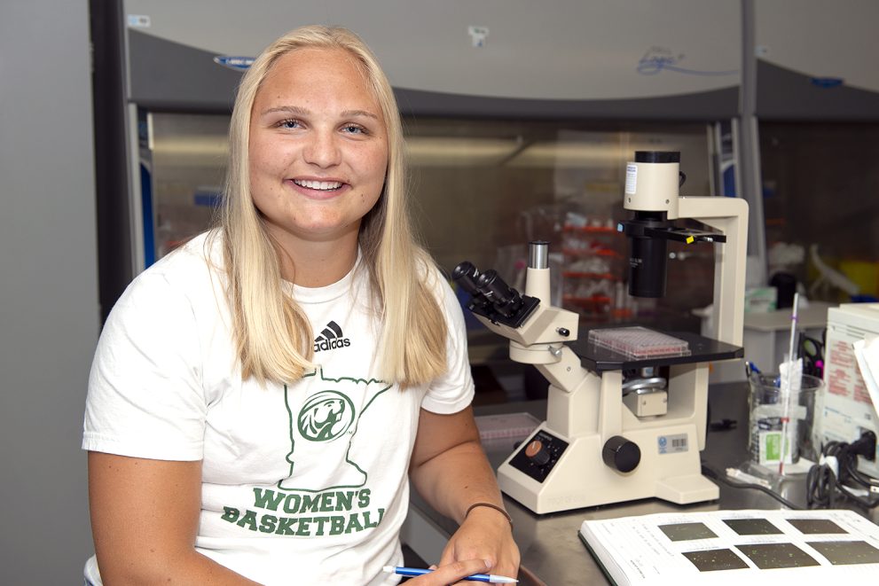 Rumer Flatness sitting in the Sattgast Hall Science Building cancer research lab.