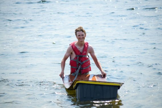 A student in BSU's Engineering Problem Solving course paddles their boat on Lake Bemidji