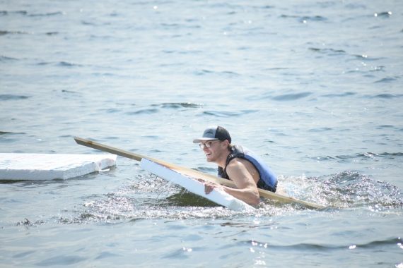 A student in BSU's Engineering Problem Solving course paddles their boat on Lake Bemidji