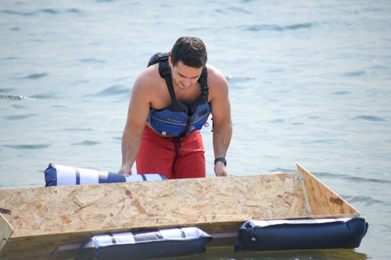 A student in BSU's Engineering Problem Solving course paddles their boat on Lake Bemidji