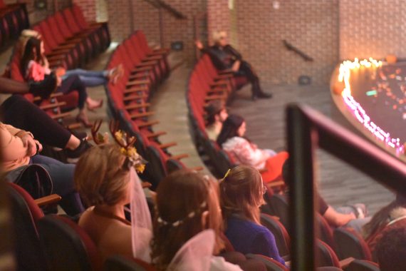 Students sitting in an auditorium in costumes