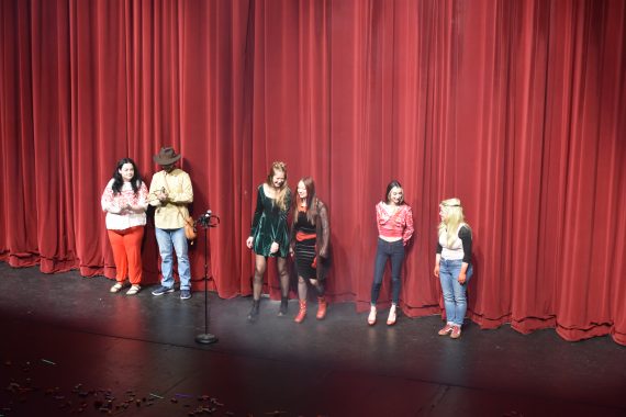 Students in costumes standing on stage