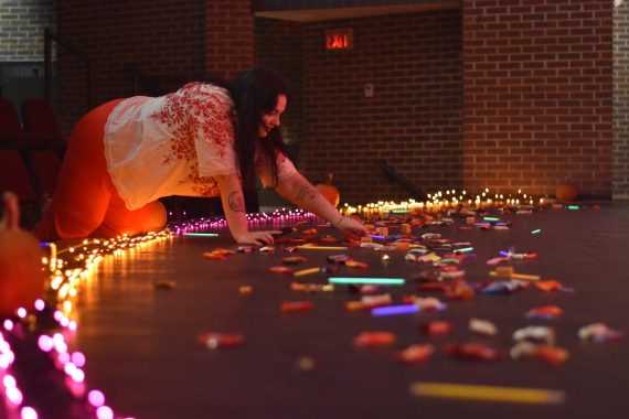 Student reaches for candy on a stage