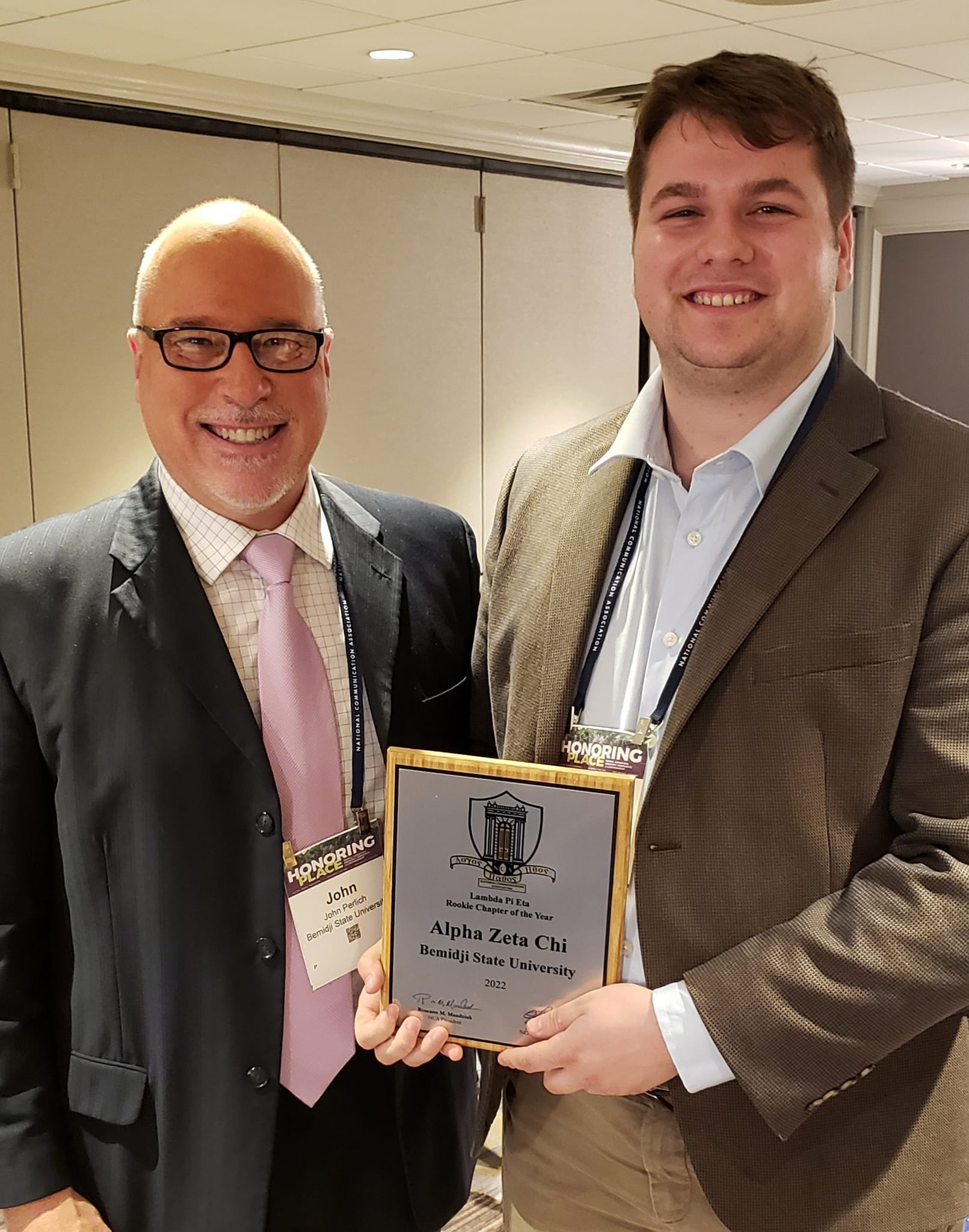 Associate professor and Alpha Zeta Chi advisor Dr. John Perlich, left, and BSU student Cameron Burnap accept the Rookie Chapter of the Year award at the NCA Annual Conference 