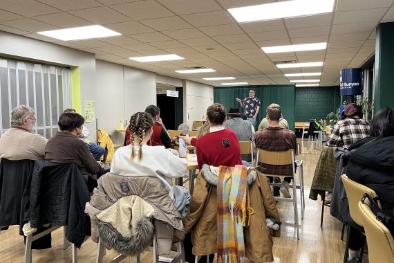 Creative writing undergraduate reading on stage during Milk Tooth 2022 winter reading