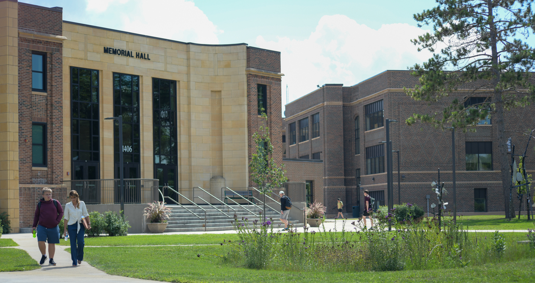 Students walk on campus in front of Memorial Hall