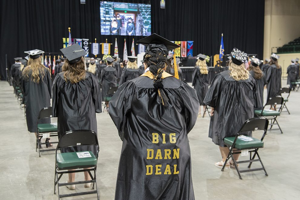 Graduation with a student who has a gown that says "Big darn deal"