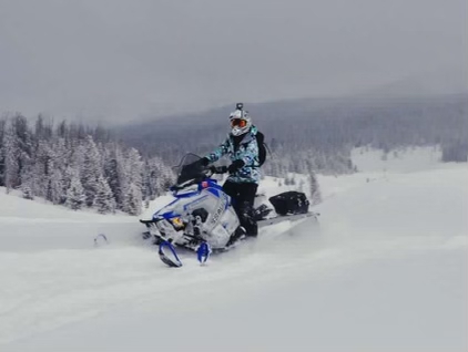 A snowmobiler riding in the mountains
