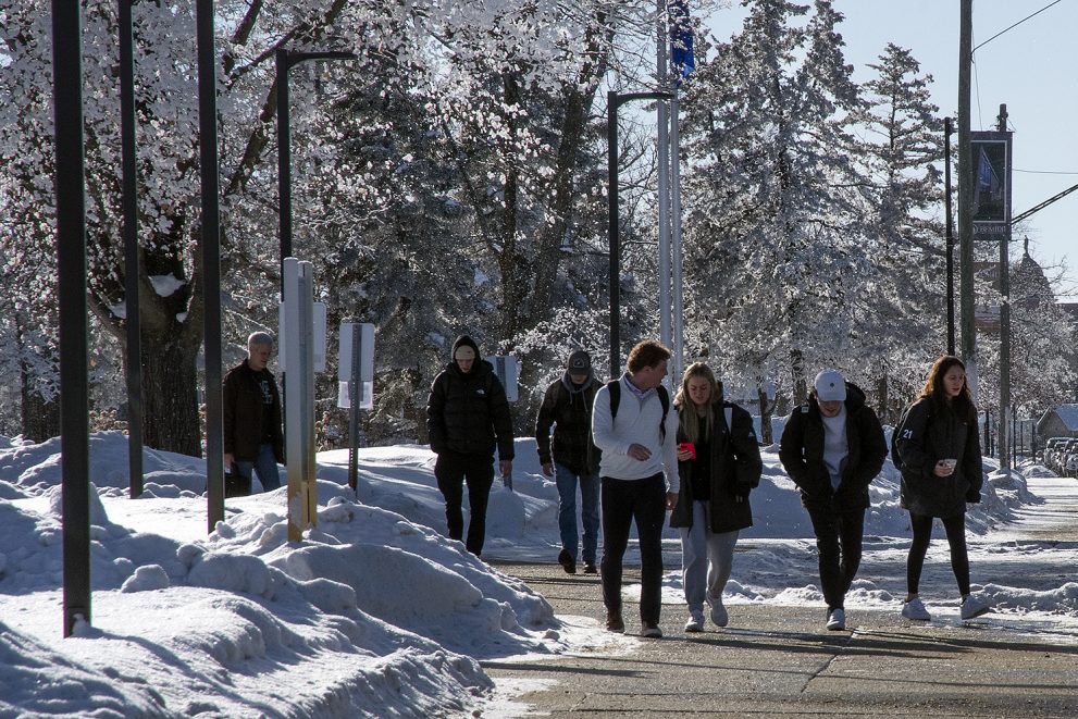 Students walking on the sidewalk outside of Bemidji State University during the first week of spring
