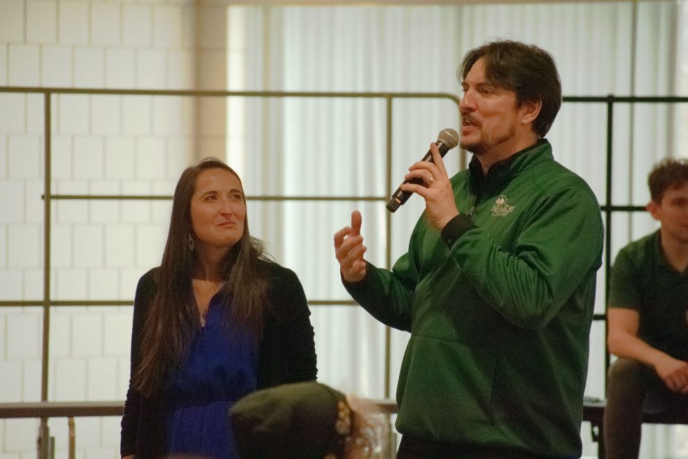 Dr. Jennifer Olson listens to Dr. Dwight Jilek, who speaks into a microphone