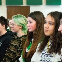 A group of seated students listens to a presenter at BSU Sings! Day