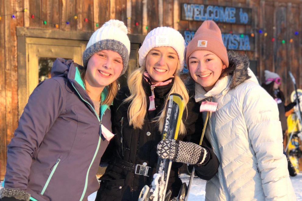 Three college students smiling in winter gear at the Buena Vista Ski Resort