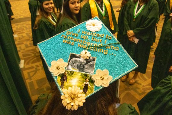 A graduation cap decorated with the phrase "I wanted to give up, but I remembered who was watching."
