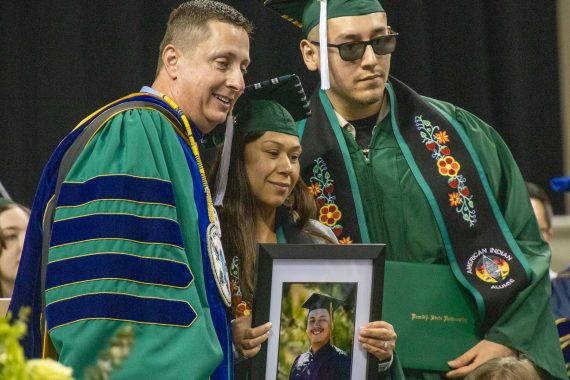 President John Hoffman poses for a photo with two graduates