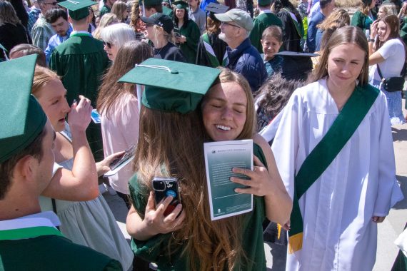 A BSU graduate hugs a family member following commencement