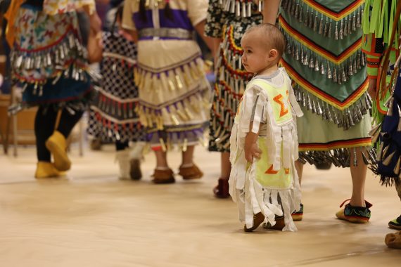 A photo of a child wearing traditional Native American clothing