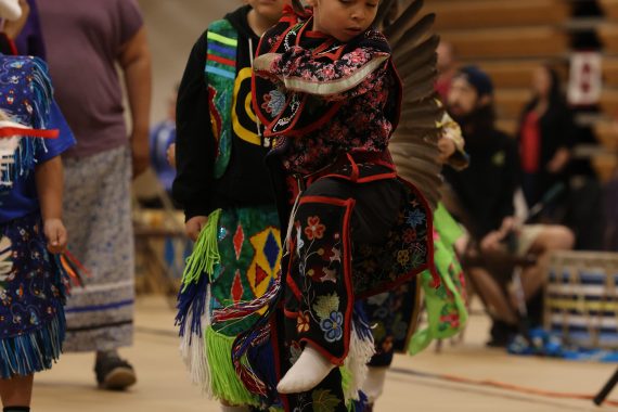 A photo of a child wearing traditional Native American clothing