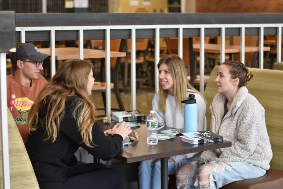 Students sitting around a table, laughing