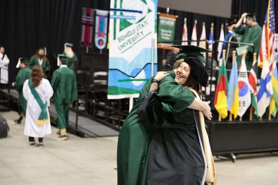 A BSU graduate hugs a faculty member